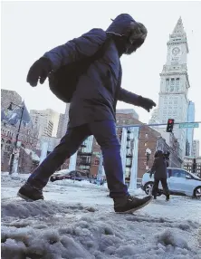  ?? STAFF PHOTO, ABOVE, BY NICOLAUS CZARNECKI; RIGHT AND TOP, BY STUART CAHILL ?? SOLUTION NEEDED: A pedestrian treads through storm debris on Atlantic Avenue in Boston yesterday. The storm expedited calls for a barrier to prevent flooding. Long Wharf, right, could be included in future plans.