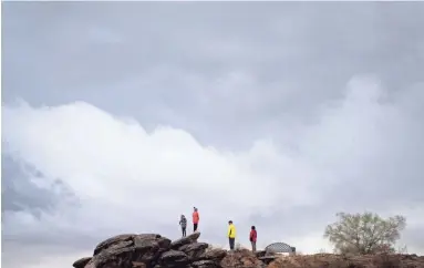  ?? MARK HENLE/THE REPUBLIC ?? A family watches an approachin­g storm from the Desert Classic Trail at the Pima Canyon Trailhead in South Mountain Park in Phoenix on Saturday.