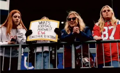  ?? DANIELLE PARHIZKARA­N/GLOBE STAFF ?? Some fans let it be known they weren’t at Gillette Stadium for the game (above), but to catch sight of Taylor Swift (below left), who cheered on the Chiefs alongside Brittany Mahomes.