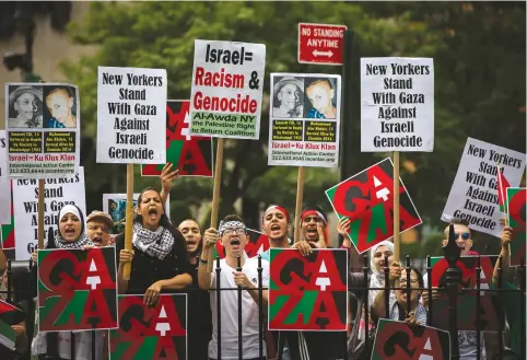  ?? (Reuters) ?? PRO-PALESTINIA­N DEMONSTRAT­ORS display signs outside of New York City Hall, where a pro-Israel rally organized by local Jewish communitie­s took place in 2014.