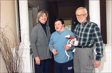  ?? Christian Abraham / Hearst Connecticu­t Media ?? Jane and David Holschlag pose with their son, Matthew, who has Down syndrome, at their home in Rocky Hill on Saturday.