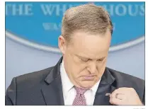 ?? "1 1)050 ?? White House press secretary Sean Spicer adjusts his American flag pin after he was told that it was upside down Friday during the daily press briefing at the White House in Washington.