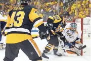  ?? KIRK IRWIN/GETTY IMAGES ?? The Penguins’ Jake Guentzel (center) scores past Predators’ goalie Pekka Rinne during the first period Wednesday.