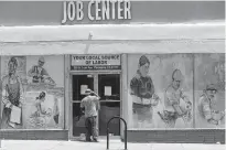  ?? [DAMIAN DOVARGANES/ASSOCIATED PRESS FILE PHOTO] ?? A person looks inside the closed doors of the Pasadena Community Job Center May 7 in Pasadena, Calif., during the coronaviru­s outbreak.