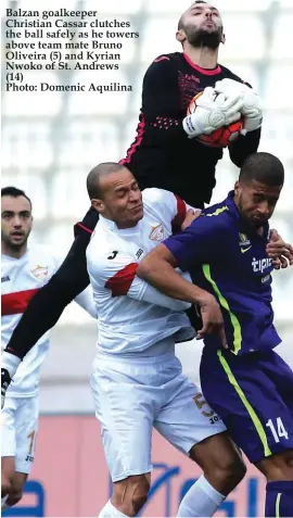  ??  ?? Balzan goalkeeper Christian Cassar clutches the ball safely as he towers above team mate Bruno Oliveira (5) and Kyrian Nwoko of St. Andrews (14) Photo: Domenic Aquilina