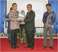  ??  ?? SAPRI Idris (kiri) menerima Ikon Guru Perpustaka­an dan Media Sekolah Menengah Labuan 2017 daripada Awang Marten.
