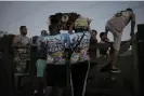  ?? ?? Members of the Balo Céu collective carry equipment into a field on the outskirts of Rio de Janeiro. Photograph: Alan Lima/The Guardian