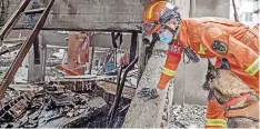  ?? | Xinhua ?? A RESCUER and a sniffer dog at a gas explosion site in Yanhu Community of Zhangwan District in Shiyan City, central China’s Hubei Province, yesterday.