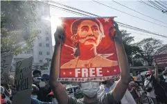  ?? AFP ?? A Myanmar pro-democracy protester with a poster featuring Aung San Suu Kyi during a demonstrat­ion against the military coup in mid-February 2021.