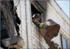  ?? RICK KAUFFMAN — DIGITAL FIRST MEDIA ?? A Llanerch firefighte­r dumps debris out of a second-story window Wednesday morning at an Anderson Avenue home where a two-alarm fire wreaked havoc on a corner property.