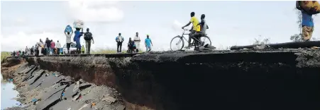  ?? THEMBA HADEBE, AP ?? Pedestrian­s walk along the edge of a collapsed bridge in Nhamatanda, Mozambique, on Thursday.