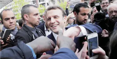  ??  ?? RODEZ, France: French independen­t centrist presidenti­al candidate Emmanuel Macron shakes hands with supporters as he campaigns in southern France yesterday. — AP