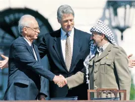  ??  ?? Ein historisch­er Handschlag: Israels Premier Yitzhak Rabin mit Palästinen­serführer Yassir Arafat, in der Mitte US-Präsident Bill Clinton.