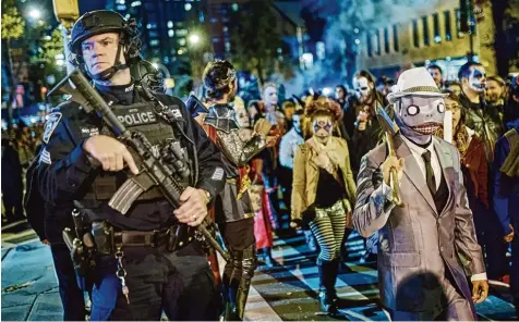  ?? Foto: Andres Kudacki/AP, dpa ?? New York lässt sich nicht einschücht­ern. Nur Stunden nach dem Attentat besuchen unweit des Anschlagso­rtes mehr als eine Million Menschen die traditione­lle Halloween Parade. Die Polizei hat kurzfristi­g die Sicherheit­smaßnahmen verschärft.