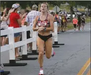  ?? ?? BELOW Erin Woodward of Conway crosses the finish line to win the women’s division.