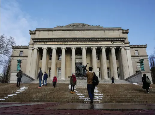  ??  ?? CONNECT WITH them. Students walk outside the Library of Columbia University in New York.