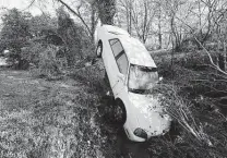  ?? Mark Humphrey / Associated Press ?? A car carried by floodwater­s leans against a tree Sunday in Nashville, Tenn., as severe storms crossed the state.