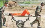  ?? — AP ?? In this Feb 2, 2002 file photo, a detainee from Afghanista­n is carried on a stretcher before being interrogat­ed by military officials at the Camp X-Ray detention facility at the Guantanamo Bay naval base in Cuba.