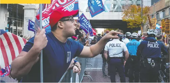  ?? RYAN R. SMITH/AFP VIA GETTY IMAGES ?? A supporter of U.S. President Donald Trump shouts at supporters of challenger Joe Biden across a barricade outside an election counting site in Philadelph­ia on Friday.