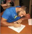  ?? COURTESY JERRY HAZZARD ?? Lake Erie College and Perry graduate Anthony Kukwa signs his NFL futures contract with the L.A. Chargers on Jan. 3.