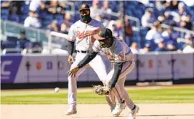  ?? SETH WENIG/AP ?? Orioles shortstop Jorge Mateo, right, commits his second fielding error of the game on a ball hit by Yankees second baseman DJ LeMahieu on Thursday.