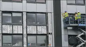  ?? AP/PETER BYRNE ?? Workers in Britain remove cladding from the Whitebeam Court residentia­l high-rise in Pendleton, Greater Manchester, on Monday.