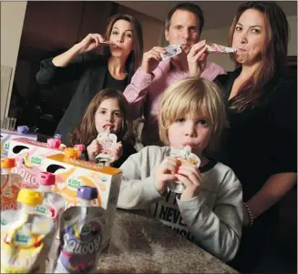  ?? Gavin Young/calgary Herald ?? Kids Gourmet co-founders and sisters Jill Voss, left, and Jennifer Carlson, stand with CEO Michael Watt and Jennifer’s children Eamon and Finley as they snack on the company’s latest product line of Squoosh organic fruit and vegetable snacks.