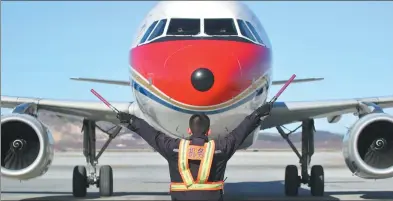  ?? TANG KE / FOR CHINA DAILY ?? A ground crew member leads a China Eastern Airlines cargo plane to land at Yantai Penglai Internatio­nal Airport in Shandong province.