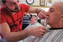  ??  ?? A barber cuts the mustache of a customer in Ahmet Guler’s barbershop in the Kasimpasa neighborho­od in Istanbul. — AP