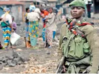  ??  ?? Κονγκολέζο­ς στρατιώτης φρουρεί ένα δρόμο στις ανατολικές περιοχές. Κυβερνητικ­οί στρατιώτες καθώς και κυανόκρανο­ι κάνουν αισθητή την παρουσία τους σε αυτή την ταραγμένη πλευρά της χώρας.