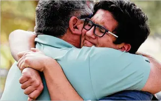  ?? MARIO TAMA / GETTY IMAGES ?? Kurt Rennels (left) hugs son Eric after reuniting at a nearby park after a shooting at Saugus High on Thursday in Santa Clarita, California. The suspect was hospitaliz­ed for a gunshot to the head.