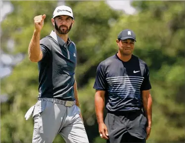  ?? MIKE EHRMANN / GETTY IMAGES ?? Leader Dustin Johnson celebrates making a birdie on No. 7 while Tiger Woods looks grim Friday during the second round of the U.S. Open at Shinnecock Hills in Southampto­n, New York. At 10 over, Woods missed the cut.
