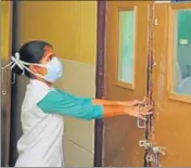  ?? PARDEEP PANDIT/HT ?? A paramedica­l worker closing the door of newly installed isolation ward at the civil hospital in Jalandhar.