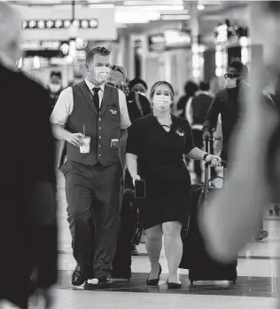  ?? Elijah Nouvelage / Bloomberg ?? Flight attendants walk through Hartsfield-Jackson Atlanta Internatio­nal Airport on April 7 in Atlanta. U.S. airlines are bringing back more pilots as they prepare for more passengers.