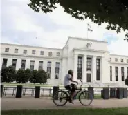  ?? — Reuters ?? A cyclist passes the Federal Reserve building in Washington, DC, US.