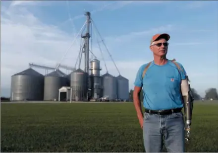  ?? AP PHOTO/MICHAEL CONROY ?? Jack Maloney poses in front of the grain bins on his Little Ireland Farms in Brownsburg, Ind., on Wednesday. Maloney, who farms about 2,000 acres in Hendricks Count, said the aid for farmers is “a nice gesture” but what farmers really want is free trade, not government handouts. American farmers will soon begin getting checks from the government as part of a billion-dollar bailout to help those experienci­ng financial strain from President Donald Trump’s trade disputes with China.