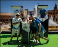  ?? ?? Supporters pose with a replica trophy at the Fan Festival area in Plaza de Espana ahead of the final in Seville