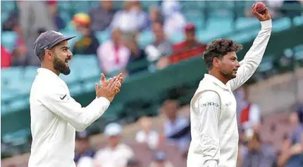  ?? – AFP ?? WELL DONE MATE: India’s Kuldeep Yadav, right, reacts as he walks off the ground with captain Virat Kohli, left, after taking five wickets during the fourth and final cricket Test between India and Australia at the Sydney Cricket Ground.