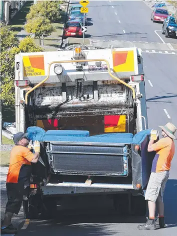  ?? Picture: GLENN HAMPSON ?? Council workmen at Labrador dispose of unwanted items during a clean-up.