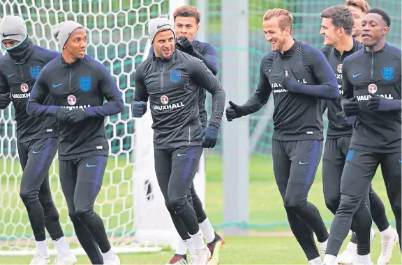  ??  ?? England captain Harry Kane in fine spirits with team-mates during a training session in the Spartak Zelenogors­k Stadium.