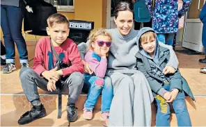  ?? ?? The actress and UN goodwill ambassador Angelina Jolie poses with children in Lviv, western Ukraine. Jolie, 46, was seen getting coffee at a cafe and signed autographs for fans while also talking to locals about the war. Thousands of refugees have fled to the city near the Polish border, which has remained largely unscathed by the fighting