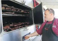  ?? MICHELLE BERG ?? Prairie Smoke and Spice’s Rob Reinhardt smokes ribs during the 2014 Ribfest. Thousands are expected at this year’s festival.