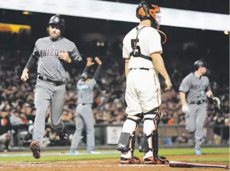  ?? Photos by Gabrielle Lurie / The Chronicle ?? A.J. Pollock scores one of three runs Arizona got on the biggest play of the night, a bases-loaded drive that wasn’t caught.