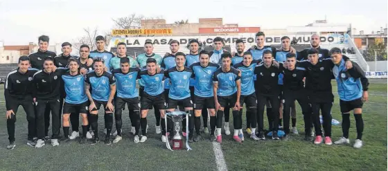  ?? ?? HAY plantel. En el triunfo ante Rosario 4 a 1, el equipo del Santo posó con el trofeo de campeón de la Federación de Fútbol Bonaerense Pampeana.