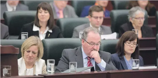  ?? THE CANADIAN PRESS/ FILES ?? Premier Rachel Notley, left, Minister of Transporta­tion and Infrastruc­ture Brian Mason and Aboriginal Affairs Minister Kathleen Ganley read over the 2015 budget in the legislatur­e last week. Getting down to work on the NDP’s first budget is proceeding...