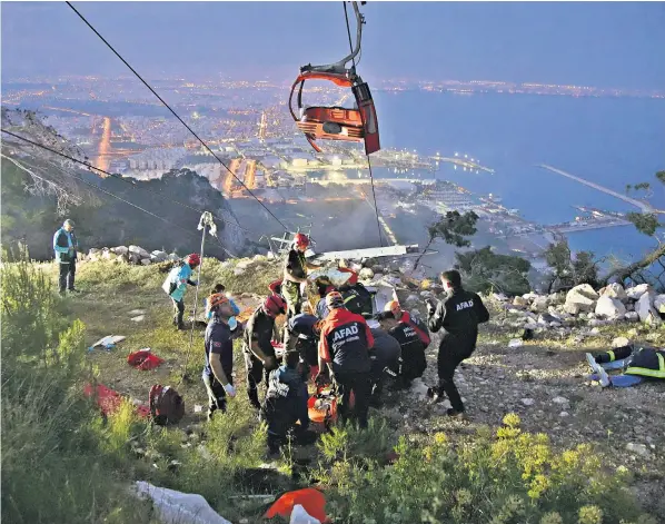  ?? ?? Crew members from Turkey’s Disaster Management Authority launched a rescue operation after a cable car collided with a broken pole before plummeting to the rocky ground in Antalya, on Friday afternoon
