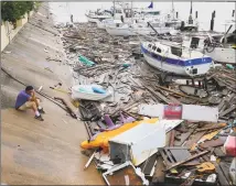  ?? Eric Gay / Associated Press ?? Allen Heath surveys the damage to a private marina after it was hit by Hurricane Hanna on Sunday in Corpus Christi, Texas. Heath's boat and about 30 others were lost or damaged.