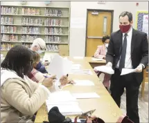  ?? Katie West • Times-Herald ?? Michael McBryde, vice president of the public finance department at Stephens Inc., hands out informatio­n to the Forrest City School Board. Stephens Inc., recently accepted a bid to refinance the district’s November 2016 bonds, saving the district almost $350,000.