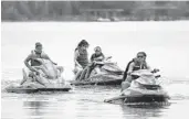  ?? STEPHEN M. DOWELL/ORLANDO SENTINEL ?? Riders on personal watercraft float through a no-wake zone on Lake Conway in Belle Isle on Saturday. The city wants to clamp down on riders who don’t follow the rules.