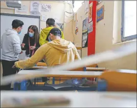  ??  ?? French teacher Marilena Petrogiann­i helps inmates to make handicraft­s in a classroom.